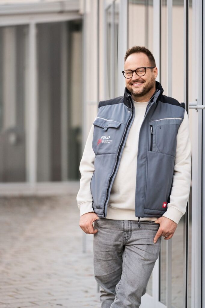Inhaber Lukas Feld von Feld Fußbodensysteme lächelt in die Kamera.