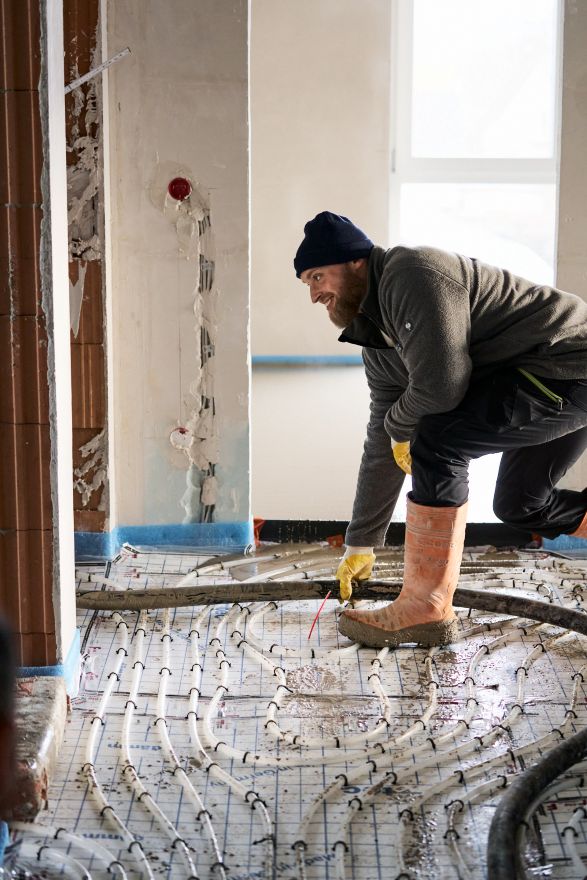 Mitarbeiter von Feld Fußbodensysteme bei der Verlegung einer Fußbodenheizung auf einer Baustelle.