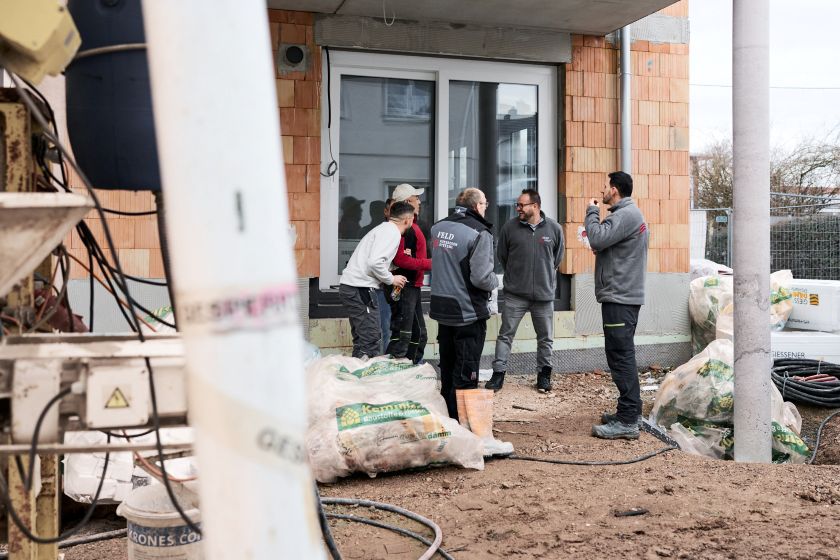 Mitarbeitende von Feld Fußbodensysteme bei der gemeinsamen Abstimmung auf der Baustelle.
